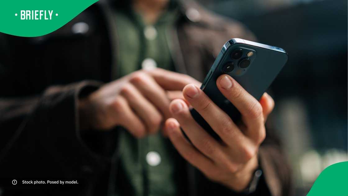 A man typing on his phone. A man typing on his phone.