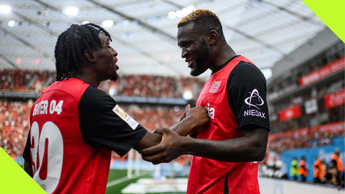 Victor Boniface and Jeremie Frimpong celebrate Bayer Leverkusen's late win over VfL Wolfsburg.