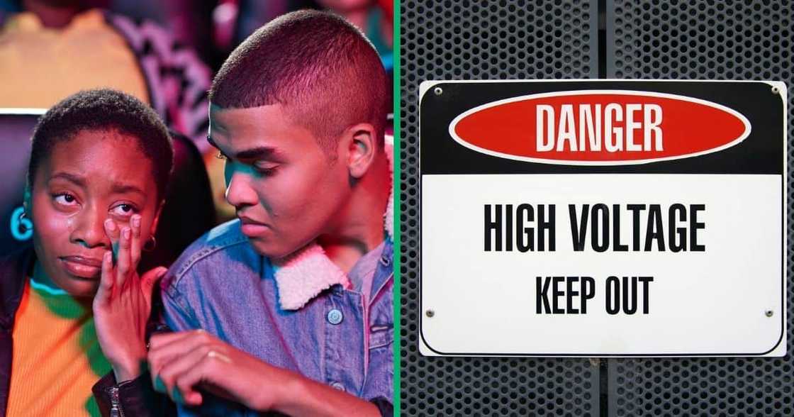 A man comforts a woman who is crying, and a high voltage warning sign on a fence A man comforts a woman who is crying, and a high voltage warning sign on a fence