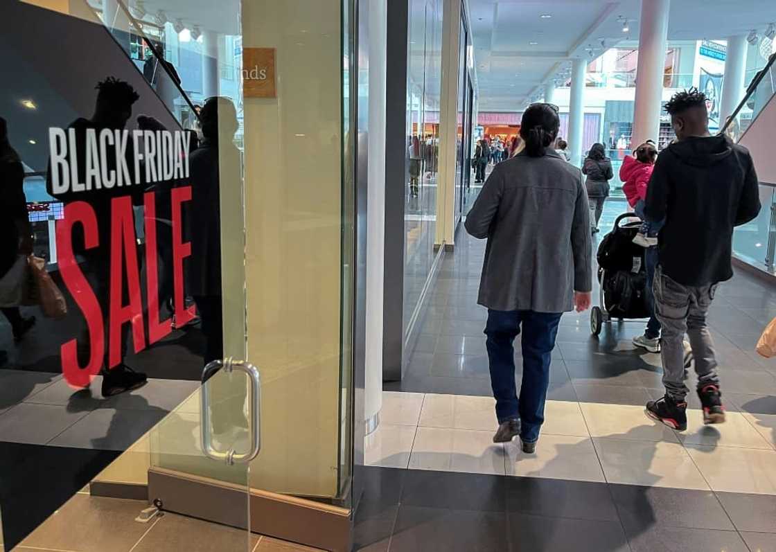 A family walks past a store advertising a Black Friday sale near Pentagon City Mall in Arlington, Virginia A family walks past a store advertising a Black Friday sale near Pentagon City Mall in Arlington, Virginia