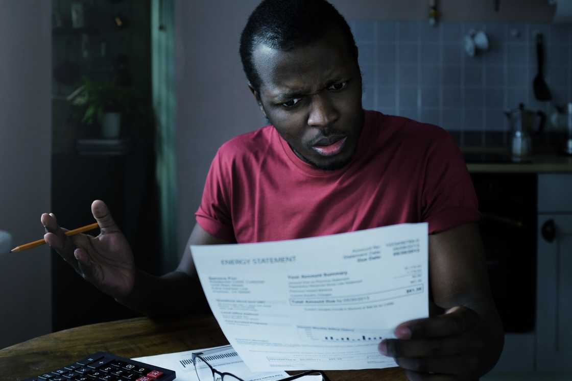 A shocked man reading a document A shocked man reading a document