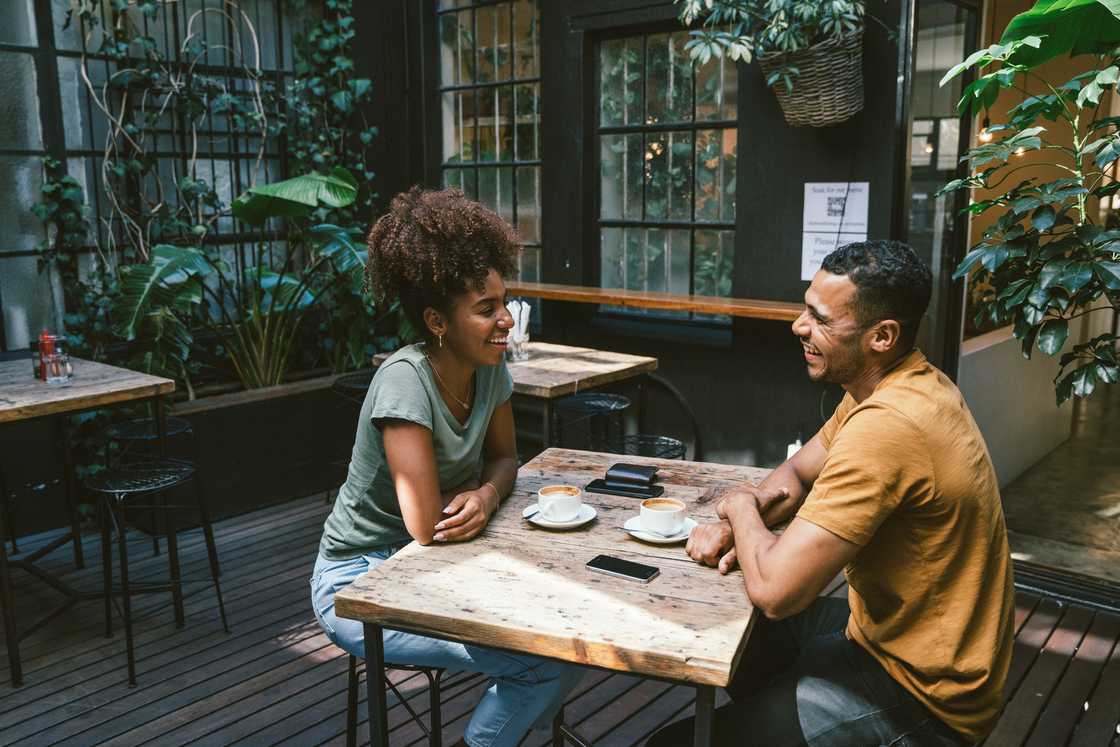 A young couple talking while sitting at a table in a cafe