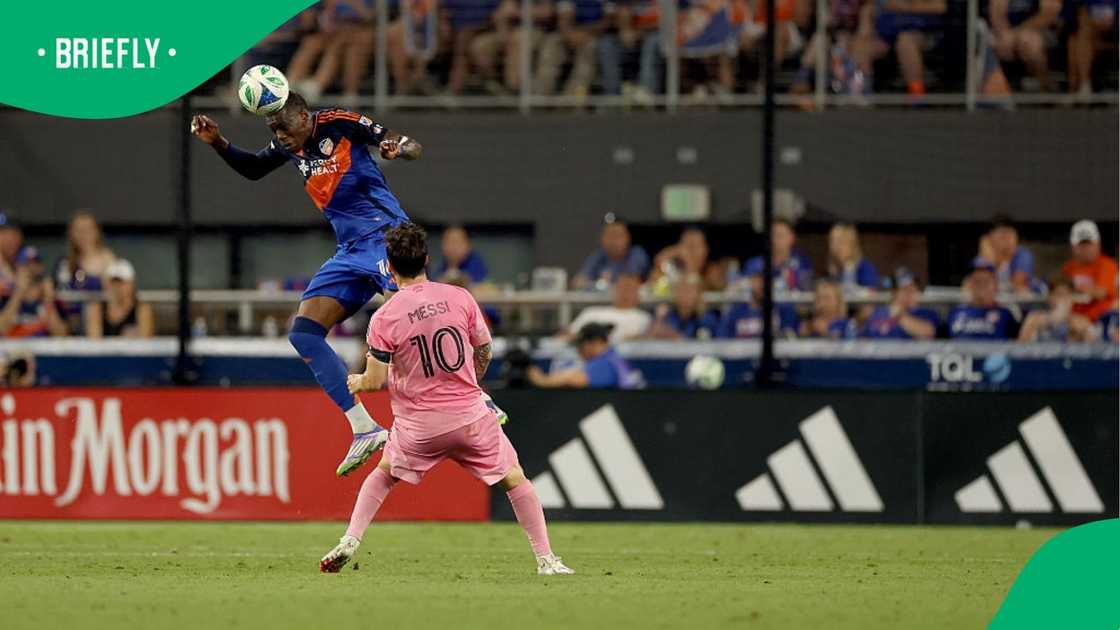 Teenage Hadebe heads the ball from Lionel Messi