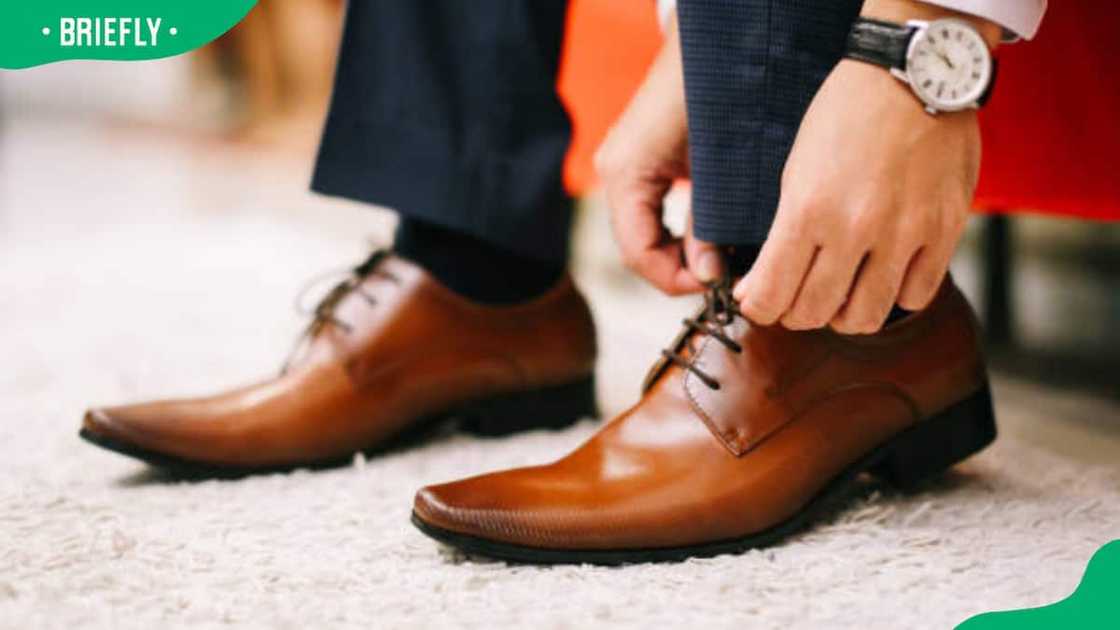 A man lacing his brown shoes A man lacing his brown shoes