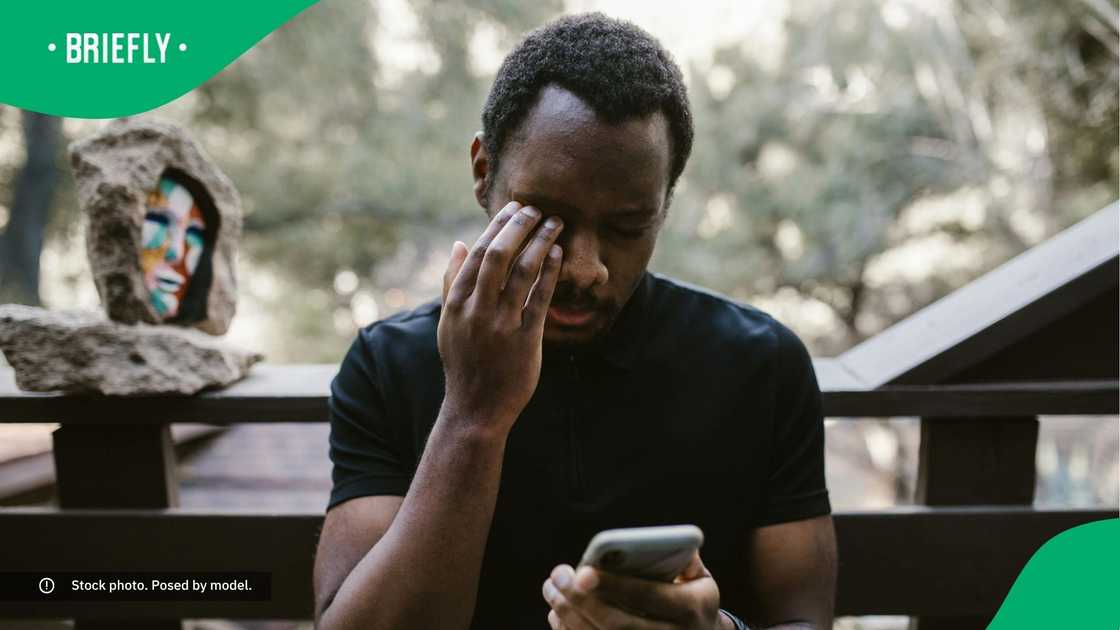 An emotional man looking at his phone.