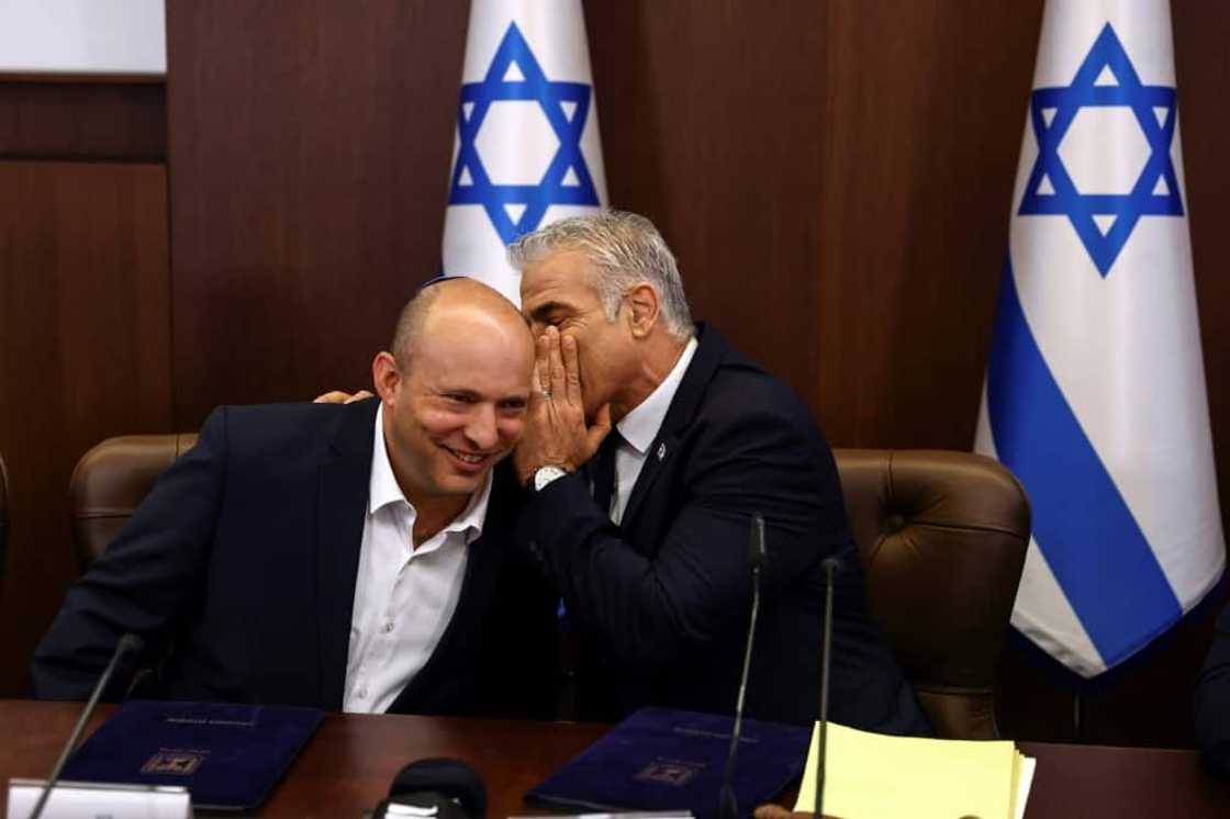 Israeli Prime Minister Yair Lapid whispers to his predecessor Naftali Bennett at the weekly cabinet meeting in Jerusalem on Sunday Israeli Prime Minister Yair Lapid whispers to his predecessor Naftali Bennett at the weekly cabinet meeting in Jerusalem on Sunday