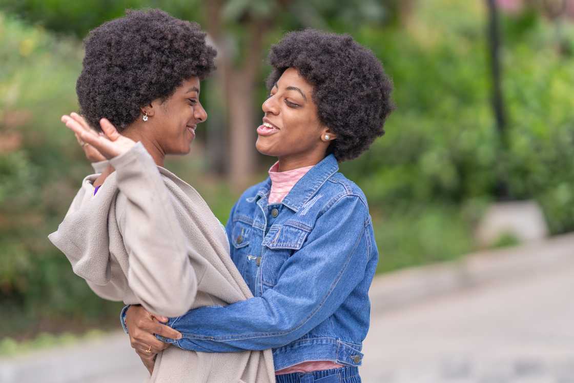 Twins standing in the park.