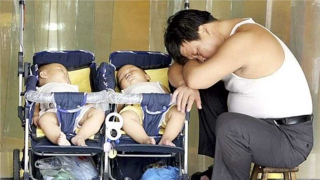 A photo of a man taking a nap with his twin babies in 2014. The picture is for an illustration purpose only. Photo source: Daily Mail