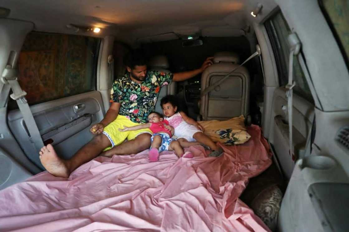 Mahmud Aguil sits with his children in the back of his air-conditioned van, his new bedroom amid power cuts and blistering summer heat Mahmud Aguil sits with his children in the back of his air-conditioned van, his new bedroom amid power cuts and blistering summer heat