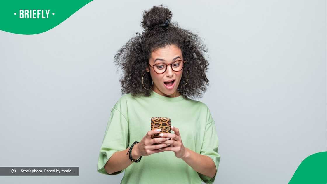 A surprised woman looking at her phone.