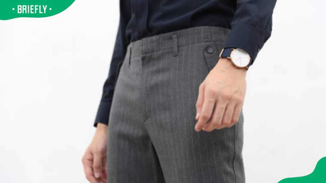 Close-up of a man in black formal shirt and gray long slack Close-up of a man in black formal shirt and gray long slack