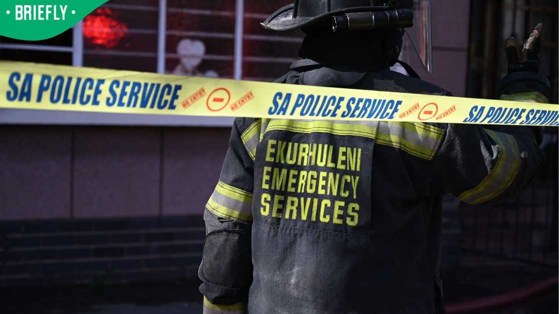 A firefighter from the City of Ekurhuleni's Emergency Service surveys the scene of a devastating fire.