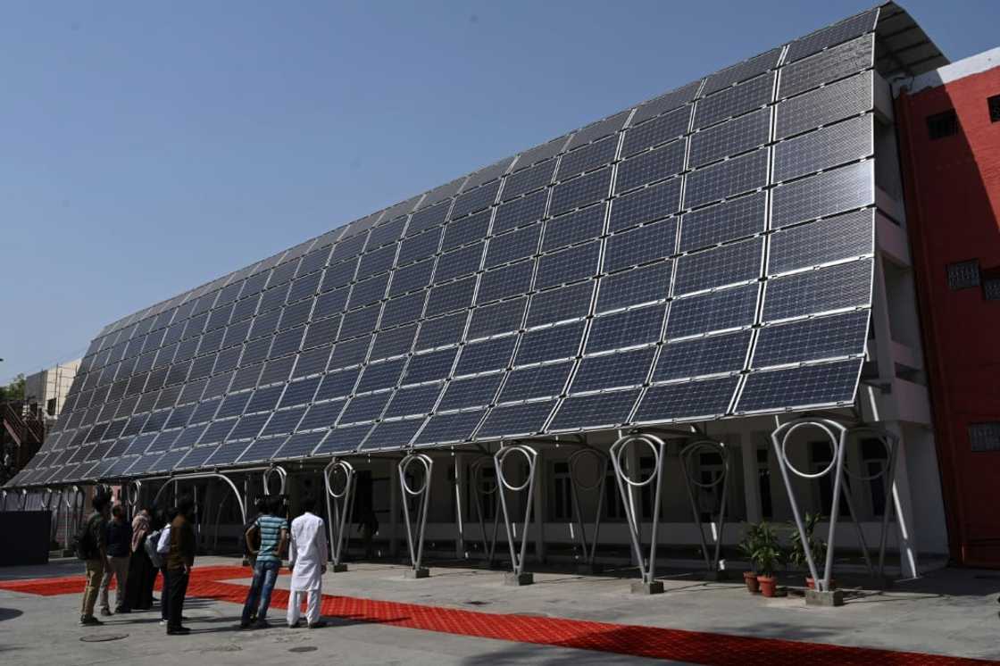 Students look at the facade of a building made with solar panels during its inauguration at the University of Engineering and Technology in Lahore in October 2020 Students look at the facade of a building made with solar panels during its inauguration at the University of Engineering and Technology in Lahore in October 2020