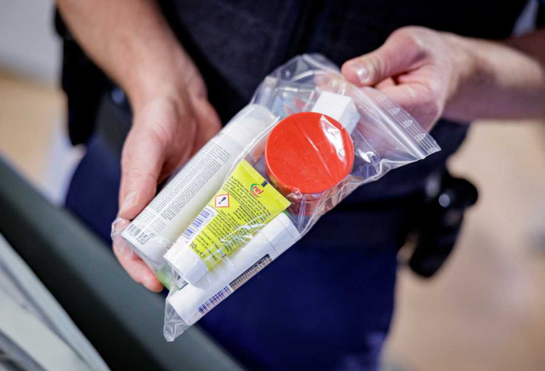 An officer checking the quantities of liquids and how they must be packed