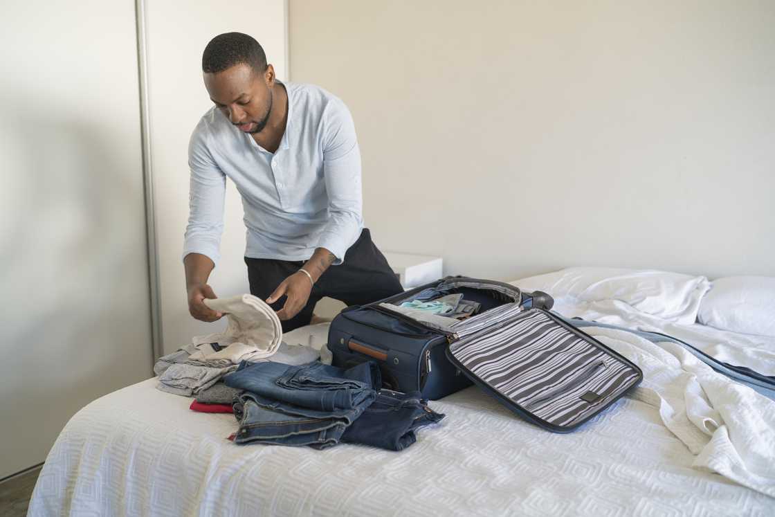 A man packs his clothes A man packs his clothes