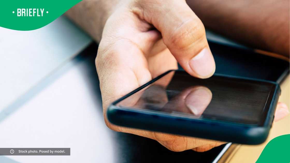 A man typing on his phone. A man typing on his phone.