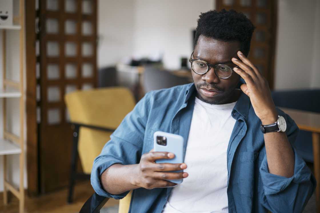 A man looking confused at his phone.