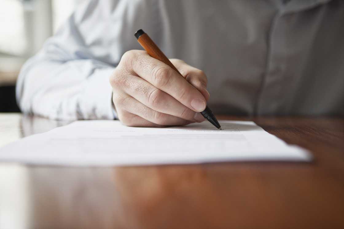 Man signs a document.