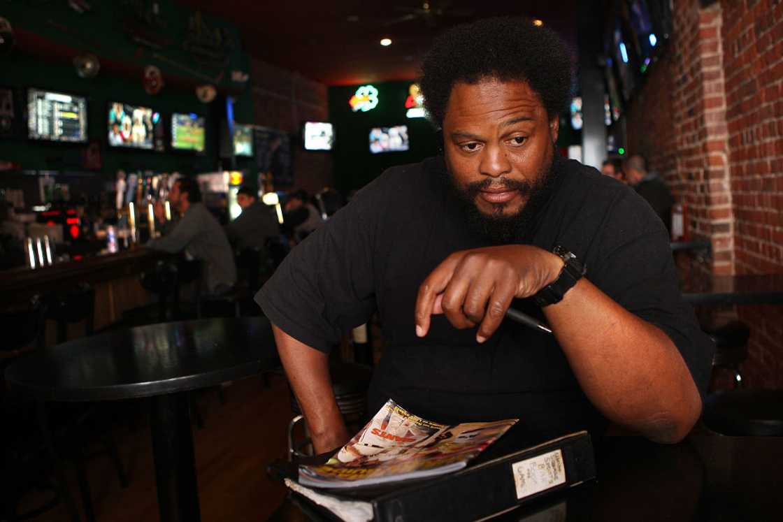 African man sits at a bar.