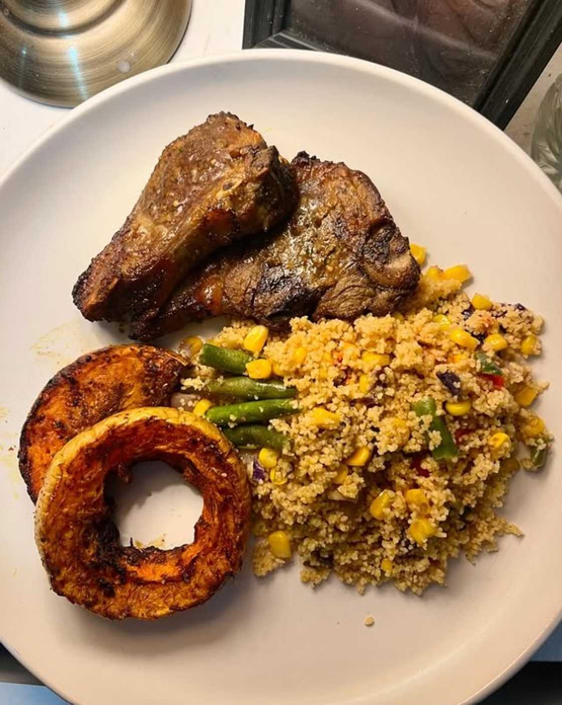 A plate of food, including meat, couscous and vegetables.