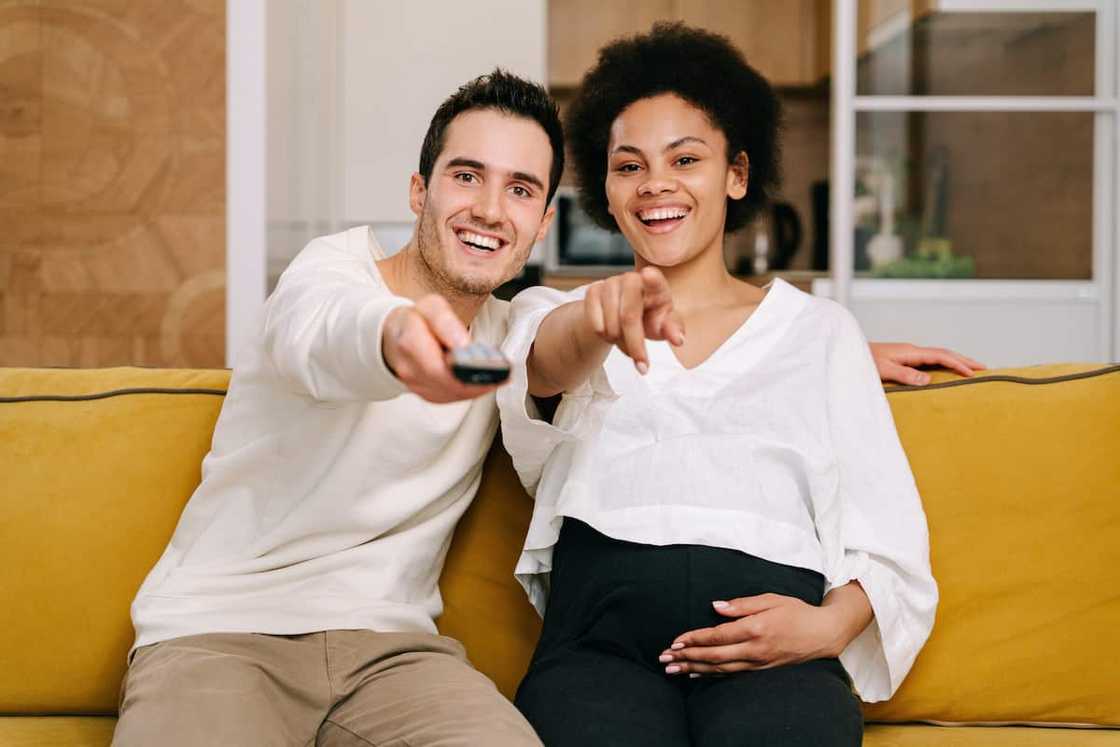 A happy couple watching television