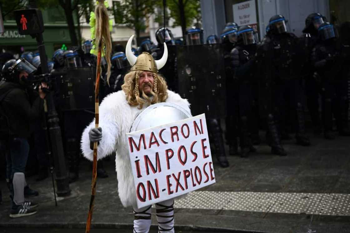 'Macron imposes, we explode,' read one protester's sign in Paris on Thursday 'Macron imposes, we explode,' read one protester's sign in Paris on Thursday