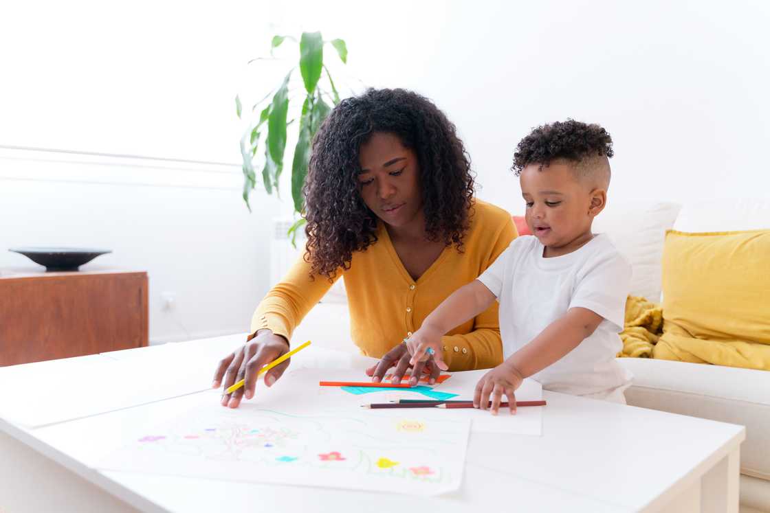 A mother watching her son draw. A mother watching her son draw.