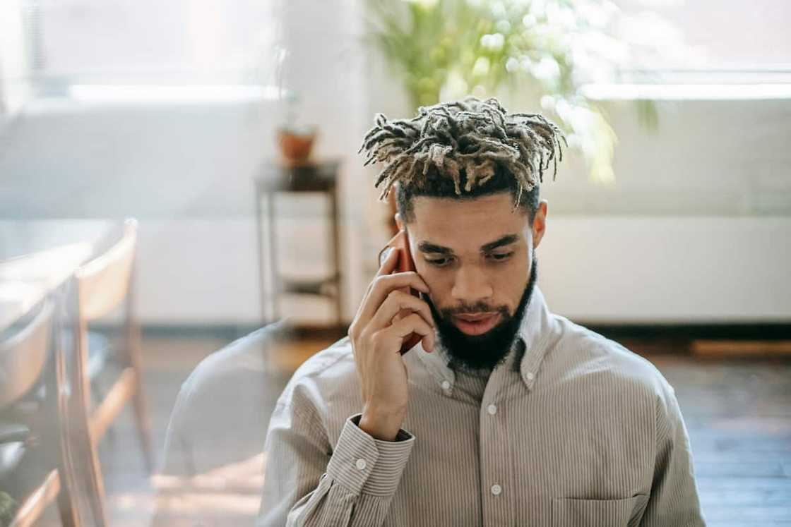 A young man in dreadlocks making a phone call A young man in dreadlocks making a phone call
