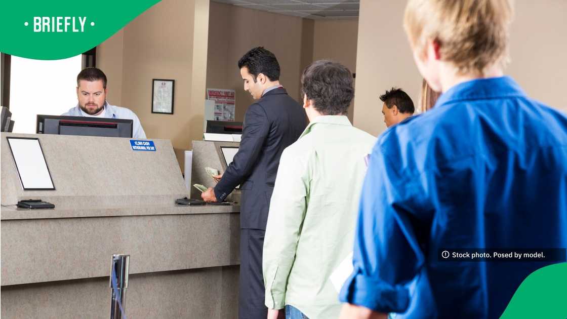A bank teller assisting customers