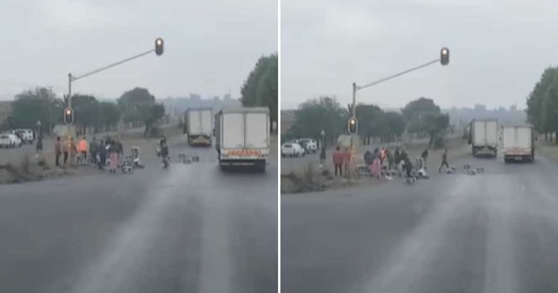 A truck that's load fell and people helping move it off of the road A truck that's load fell and people helping move it off of the road