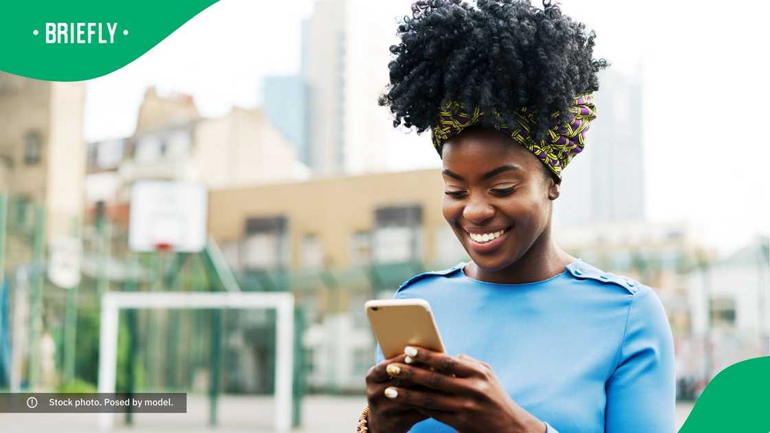 A smiling woman typing on her phone.
