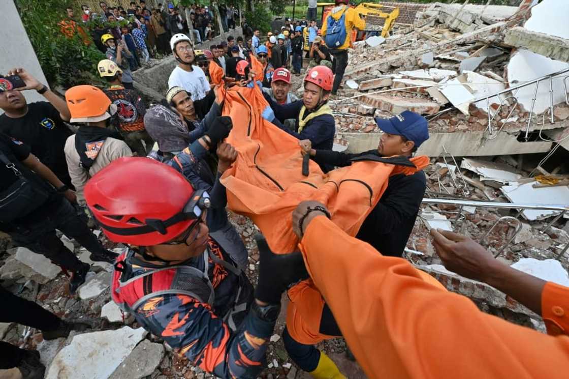 Rescue workers carry the body of a victim in Cianjur