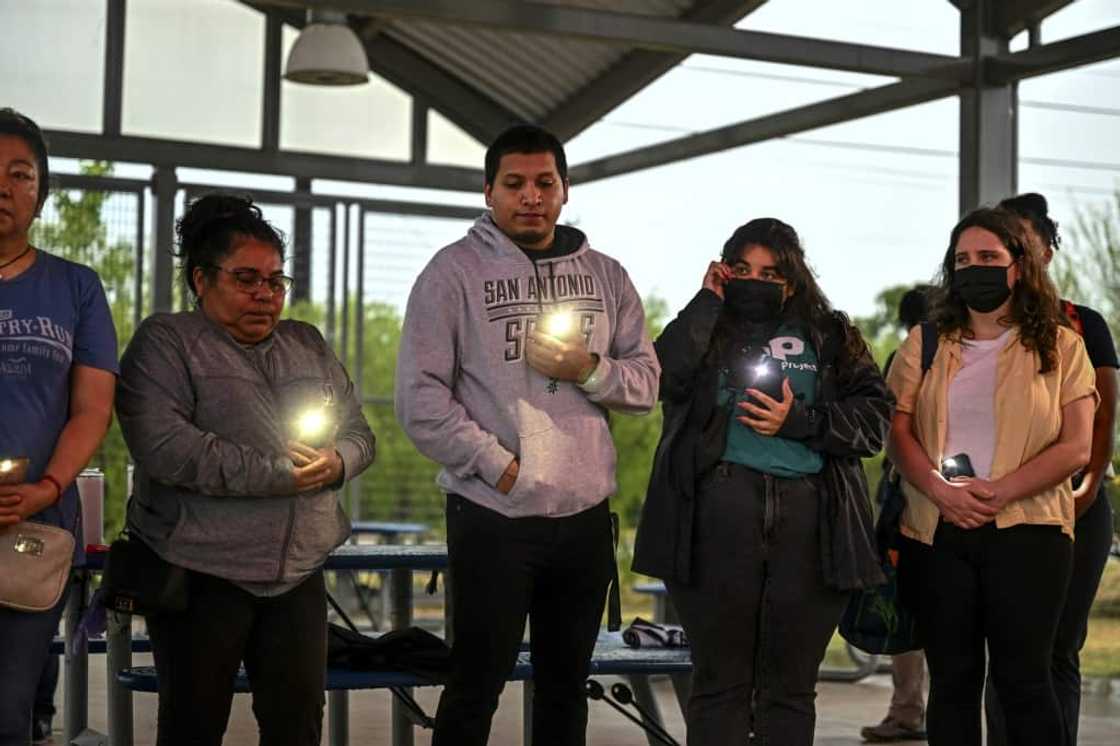 People take part in a vigil for 51 migrants who died in a tractor trailer truck in Texas