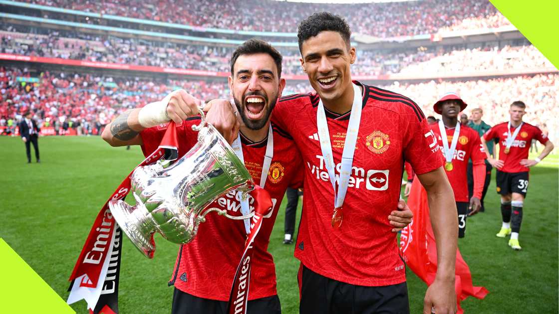 Raphael Varane and Bruno Fernandes celebrate FA CUP success.