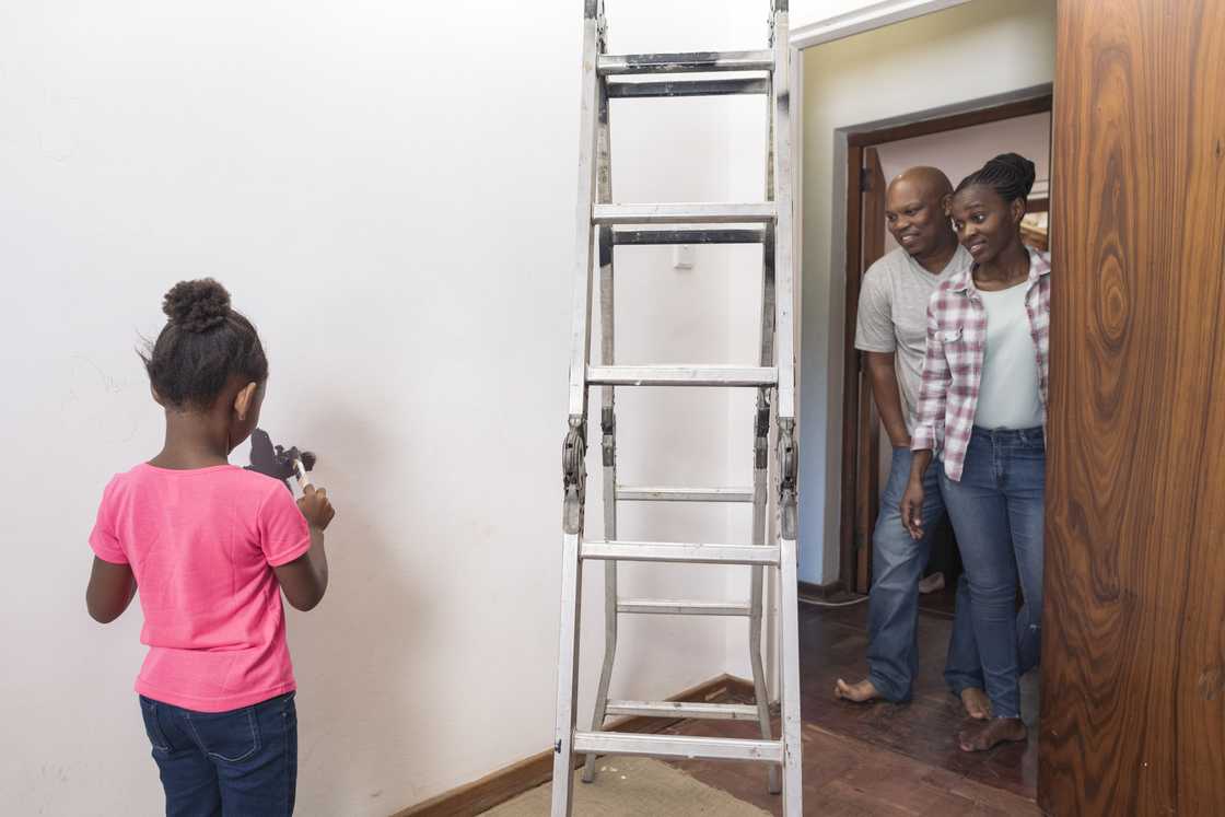 Parents admire their freshly painted children's bedroom. Parents admire their freshly painted children's bedroom.
