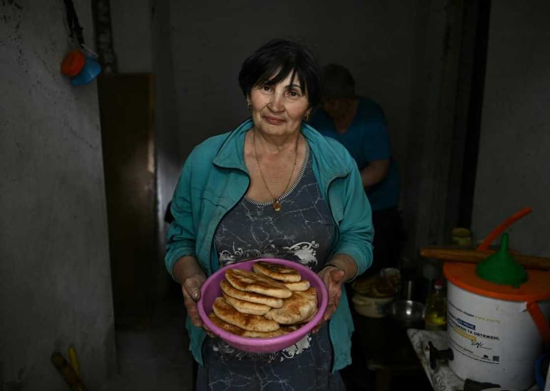 Without power for months, the neighbours cook potato pancakes over a fire Without power for months, the neighbours cook potato pancakes over a fire
