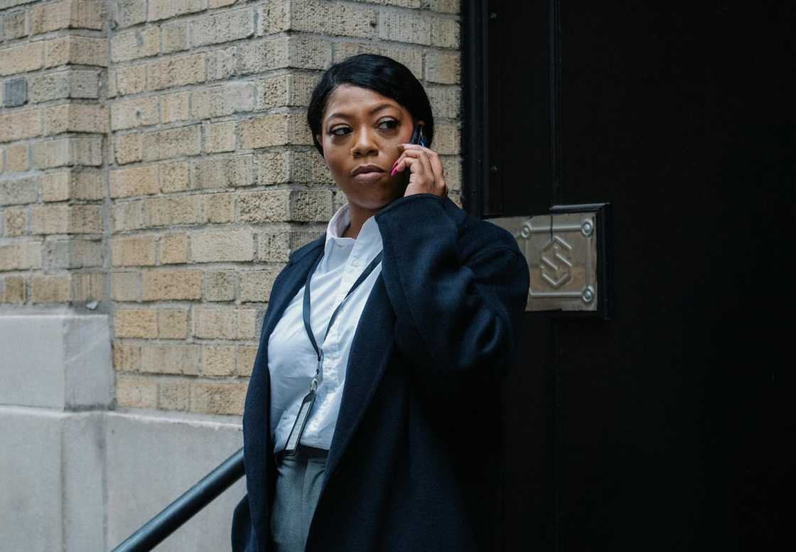 A woman in official clothing making a phone call