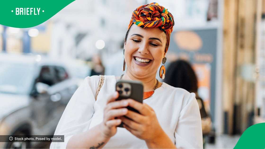 A woman laughing at her phone.