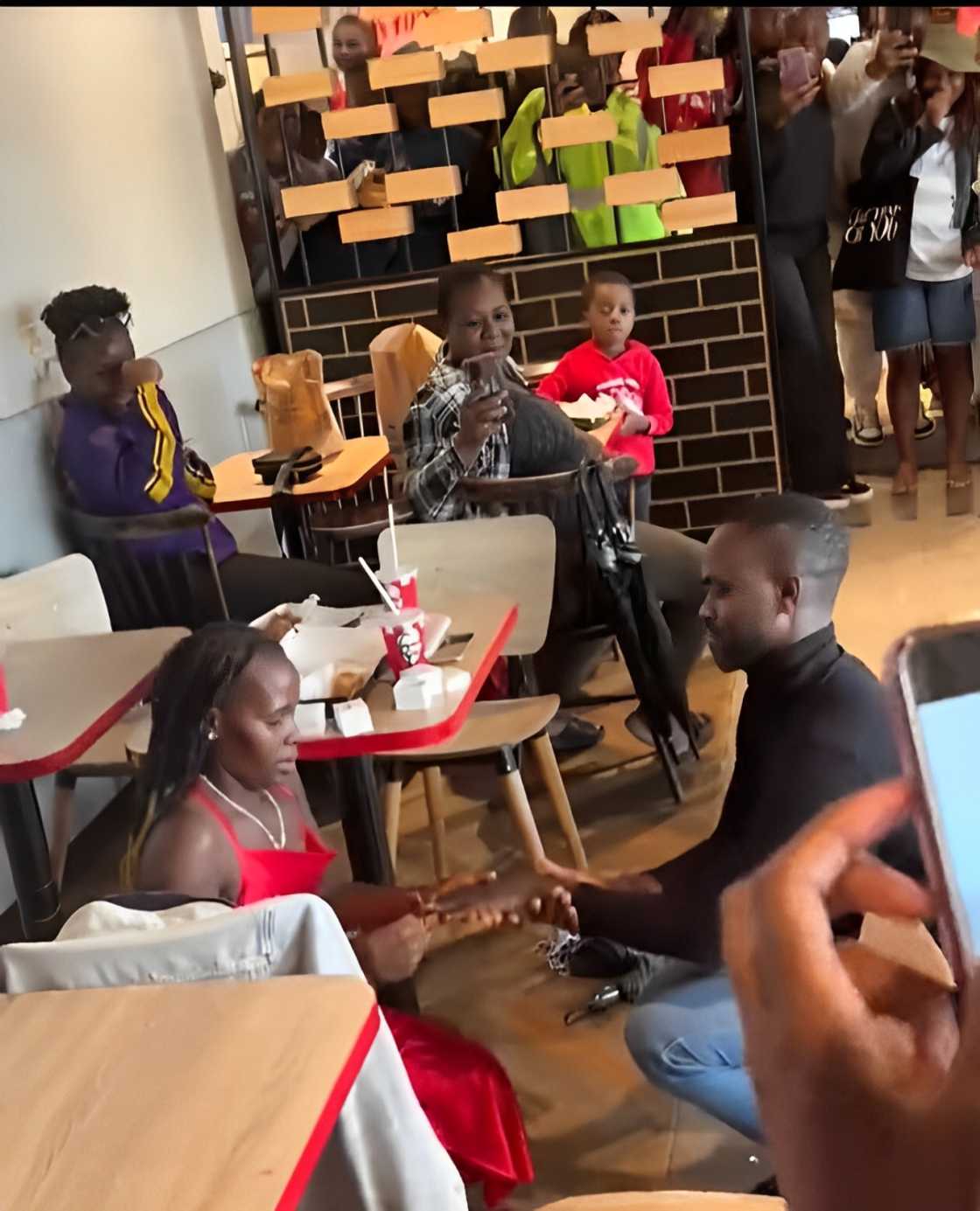 Woman kneels at KFC engagement Woman kneels at KFC engagement
