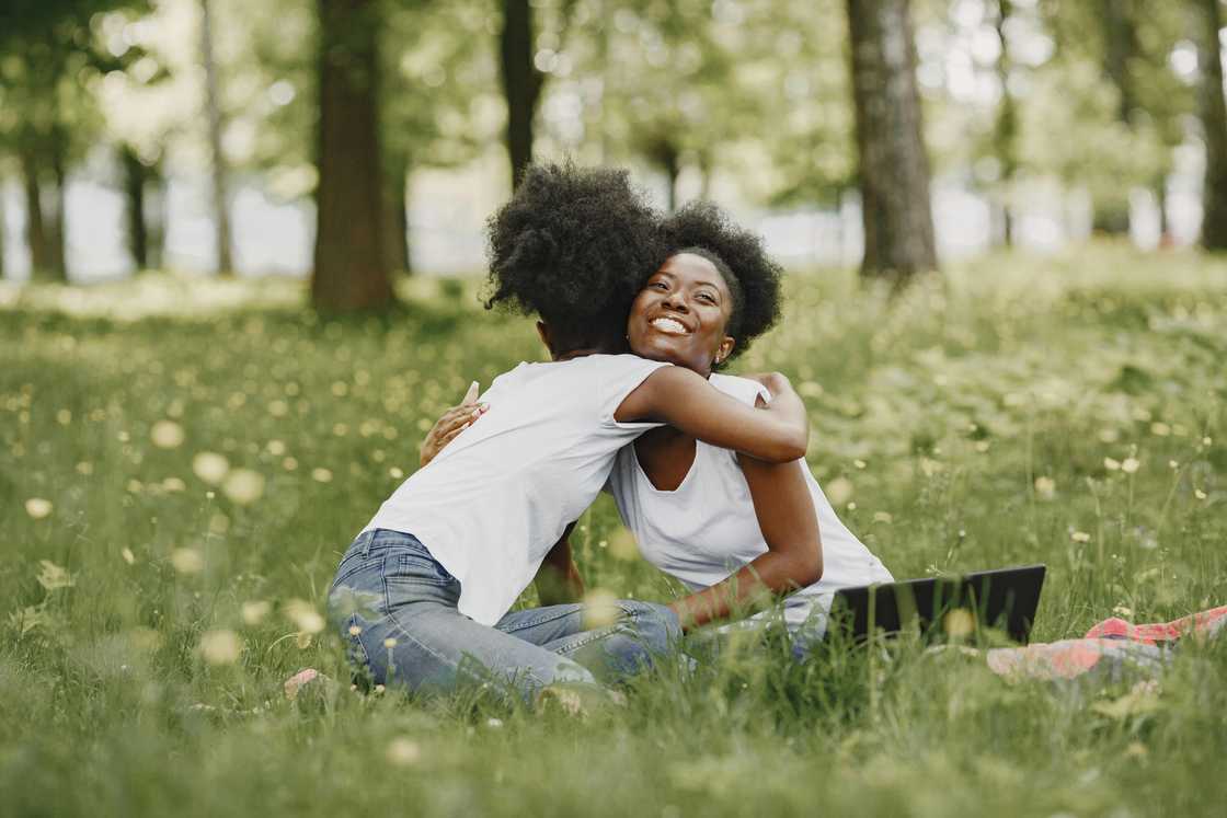 Two women sitting and hugging Two women sitting and hugging
