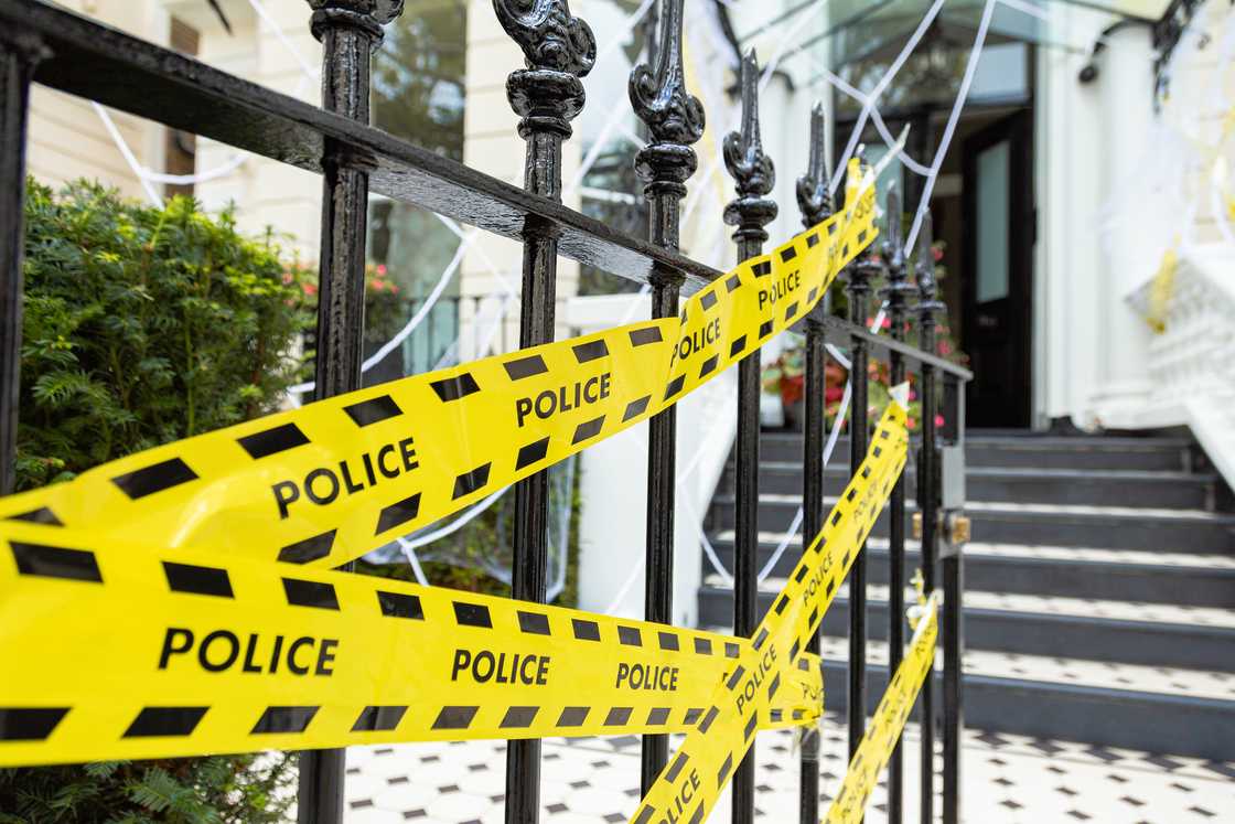 Police secure a mansion gate after an arrest.