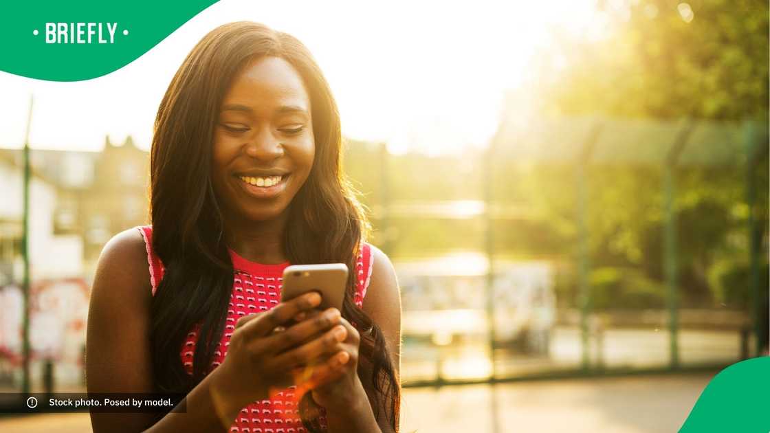 A woman smiling at her phone. A woman smiling at her phone.