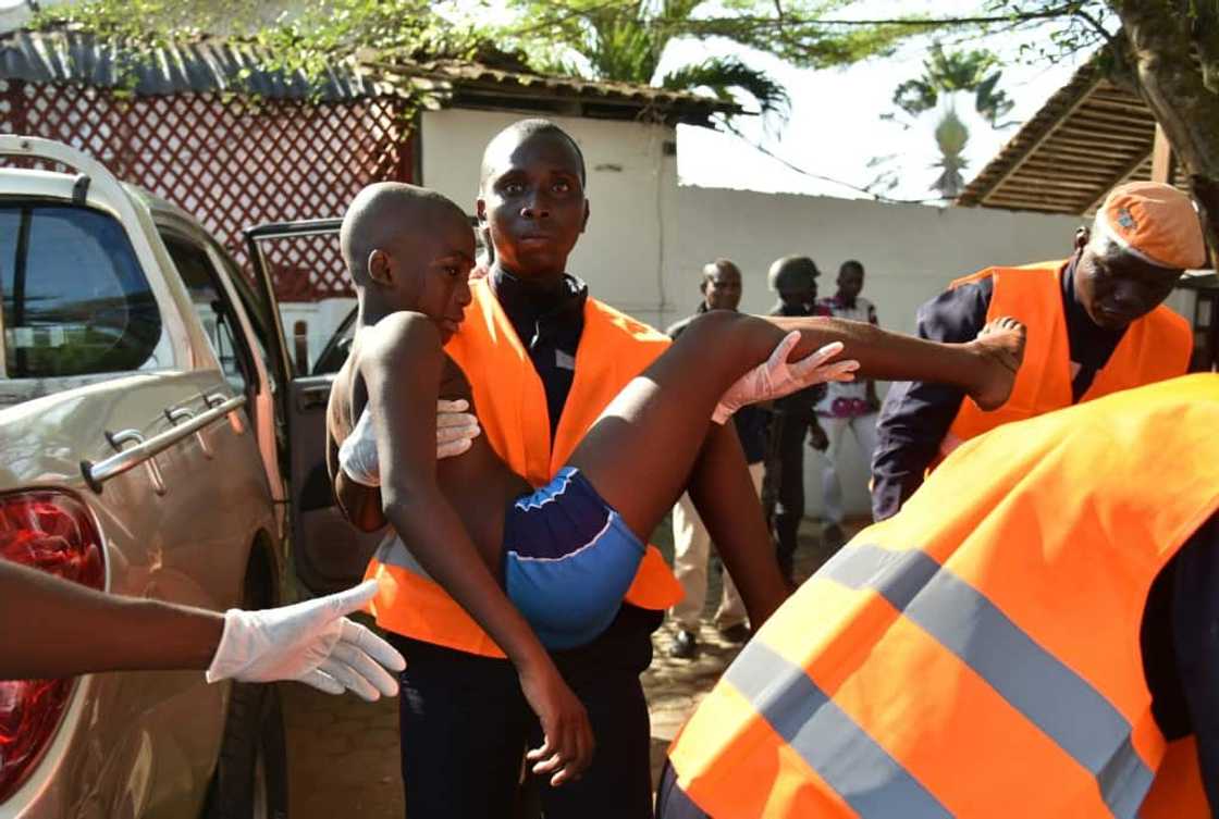 A rescue worker carries a young boy who was wounded in the attack