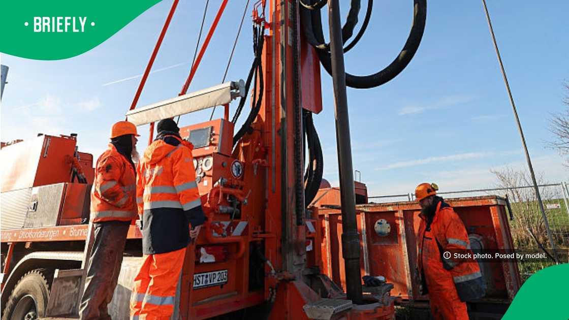 The crew monitored the controls of the heavy machinery as the mechanical drill bored into the ground The crew monitored the controls of the heavy machinery as the mechanical drill bored into the ground