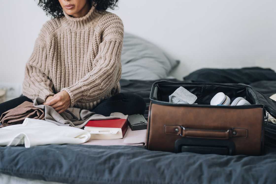 A woman packing her clothes in a suitcase A woman packing her clothes in a suitcase