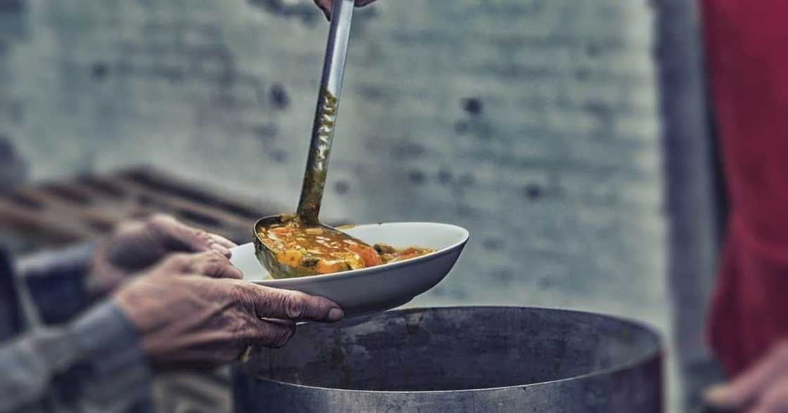 Homeless and hungry person served soup Homeless and hungry person served soup