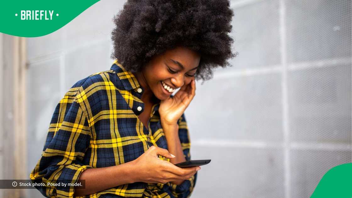 A woman laughing at her phone. A woman laughing at her phone.