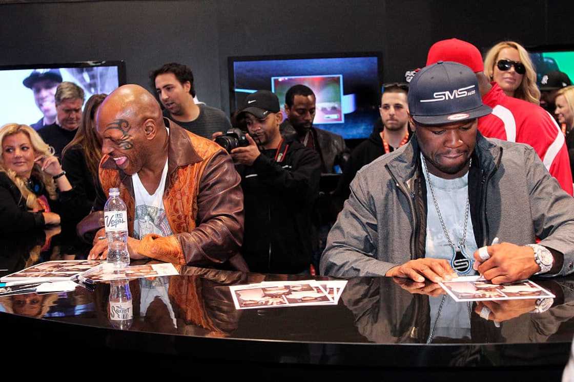 Mike Tyson and 50 Cent signing autographs