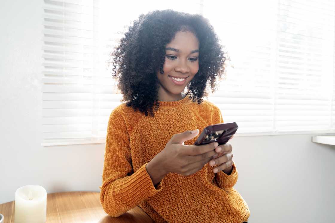 A woman smiling at her phone. A woman smiling at her phone.