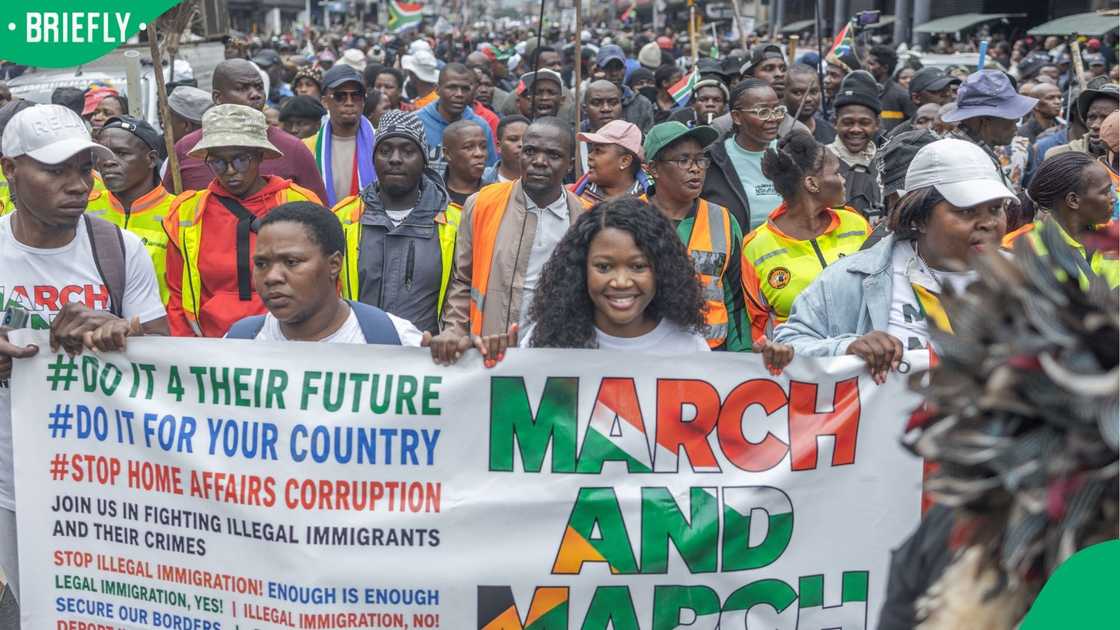 Protesters hold a banner as they march during a demonstration by the "March and March" movement